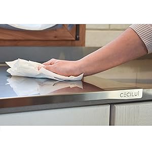 plan de travail sur le dessus de la cuisine avec une main qui la nettoie avec du papier absorbant.